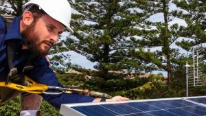 Ein Solarteur installiert eine Photovoltaikanlage.